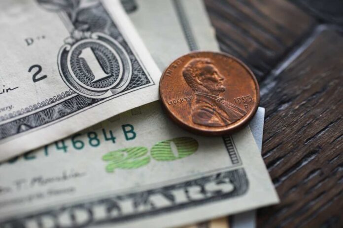 Close-up,Of,American,Dollar,Bills,And,Penny,On,Wooden,Surface