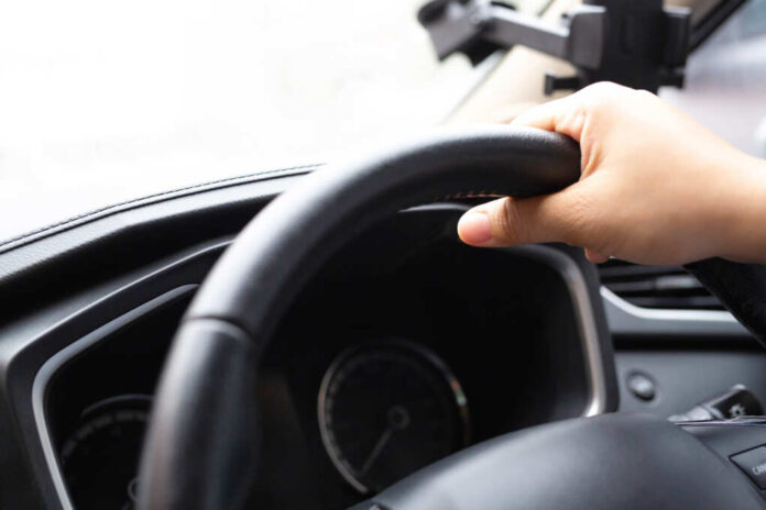A,Woman,Caught,The,Steering,Wheel,Of,A,Car,While