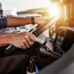 Massive CDL Oversight Failure Exposes Families to Risk Close-up of a truck driver's hands on the steering wheel inside a vehicle
