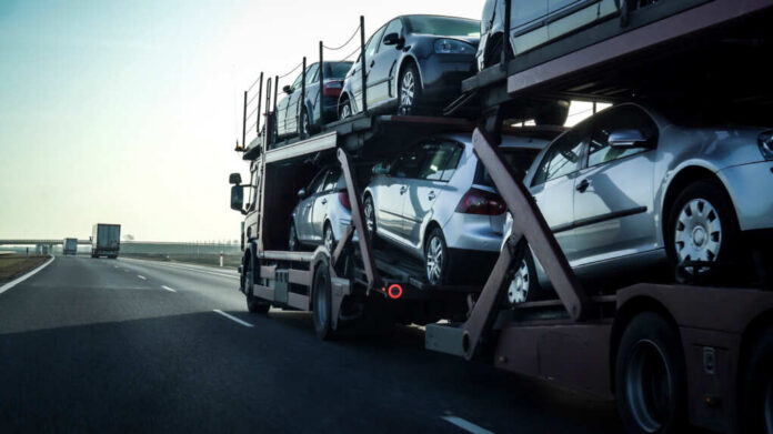 A truck transporting multiple cars on a highway