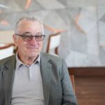 Elderly man in a casual outfit smiling in a modern interior