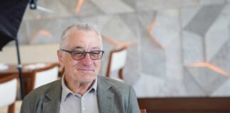 Elderly man in a casual outfit smiling in a modern interior