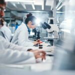 Scientists working in a laboratory with microscopes and test tubes