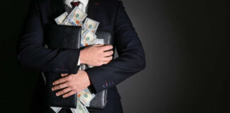 Businessman holding a briefcase filled with cash
