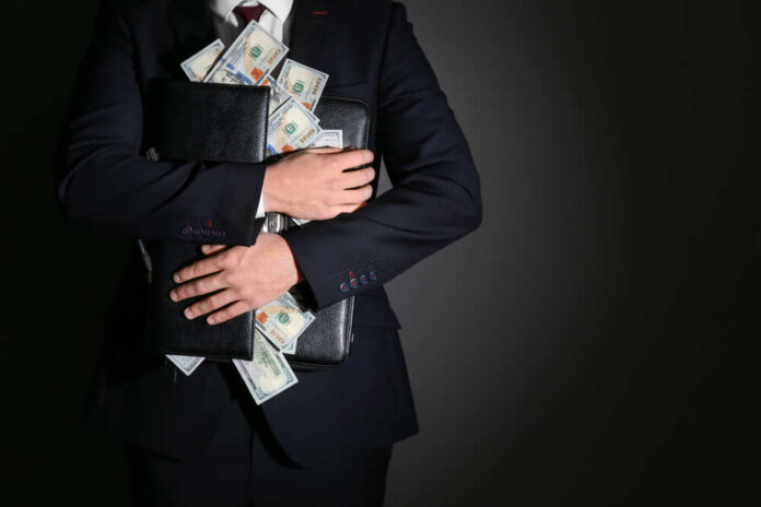 Businessman holding a briefcase filled with cash