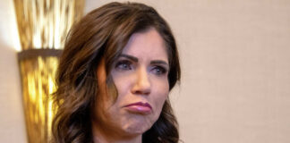 A woman with a concerned expression in a formal outfit