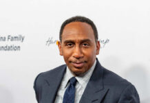 A man in a suit poses for a photo at a formal event