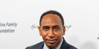 A man in a suit poses for a photo at a formal event
