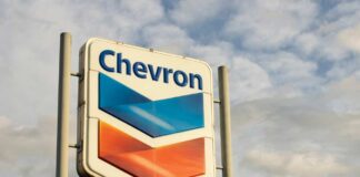 Chevron gas station sign against a cloudy sky
