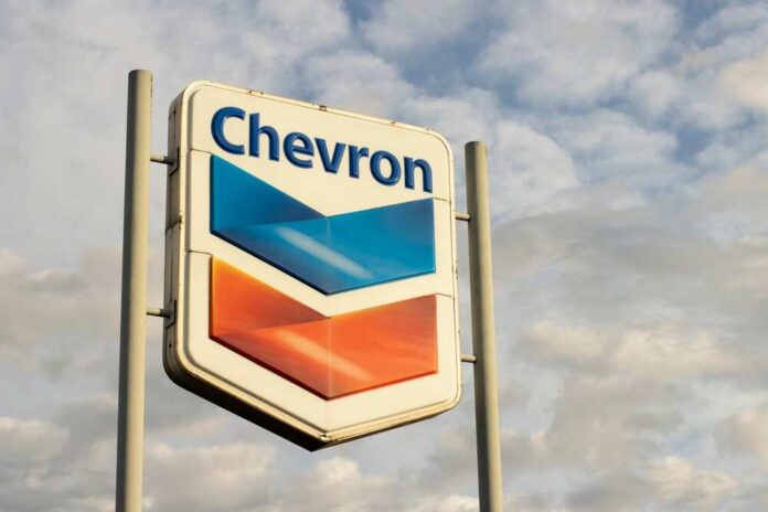 Chevron gas station sign against a cloudy sky