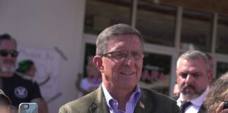 A man in a blazer interacting with a crowd during a public event