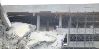 Damaged building structure with exposed debris and scaffolding