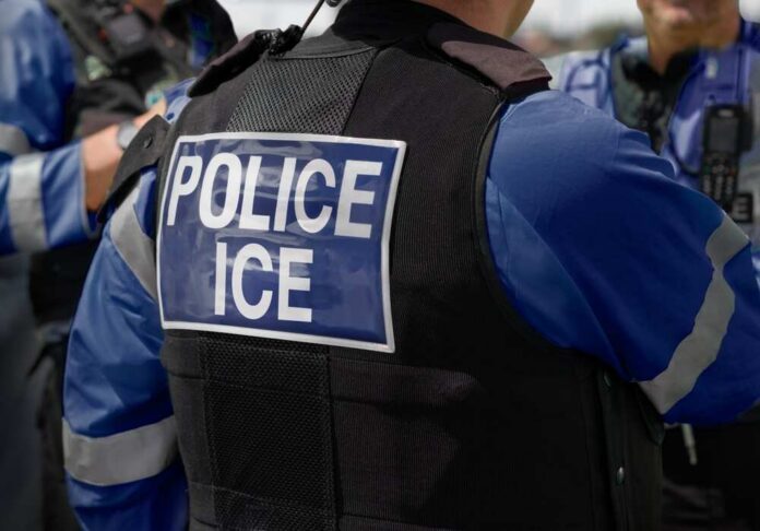 Close-up of a police officer's vest with 'POLICE ICE' label