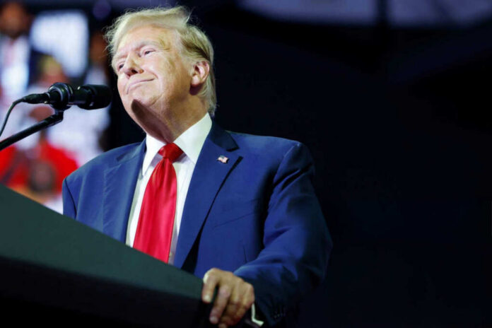 A man in a suit speaking at a podium with a microphone