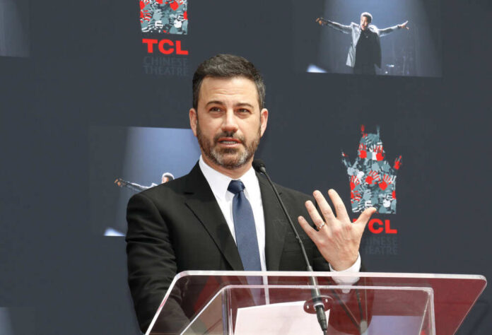 A man in a suit speaking at a podium during an event at TCL Chinese Theatre