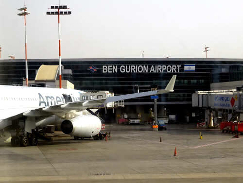 An airplane parked at Ben Gurion Airport with the terminal in the background
