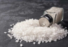 Salt Myths Exposed: Are We Eating Wrong? A glass salt shaker tipped over with salt spilling out