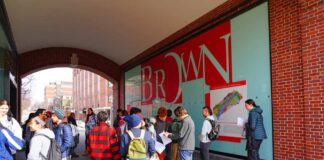 Students gathered outside a building at Brown University, engaging with informational materials