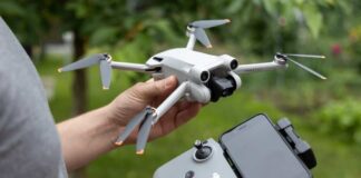 Person holding a drone and its remote control outdoors