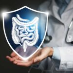 A doctor holding a digital shield with a graphic of the digestive system