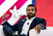 A man in a suit speaking passionately during a conference panel discussion