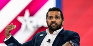 A man in a suit speaking passionately during a conference panel discussion
