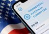 DNC’s Attack on Trump BACKFIRES—$1.8 Trillion Reveal Mobile phone displaying Democratic National Committee website on an American flag background
