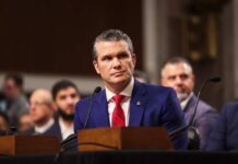 Individual in formal attire seated at a senate hearing