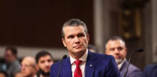 Individual in formal attire seated at a senate hearing