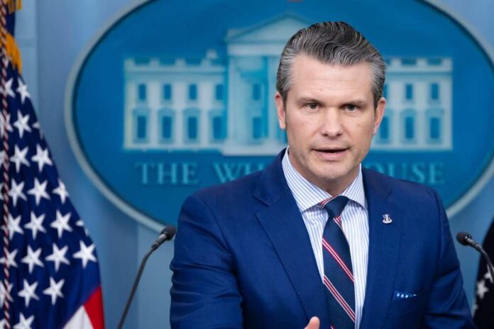 A government official speaking at a press briefing in front of the White House backdrop
