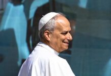 A religious leader in papal attire smiling during a public appearance