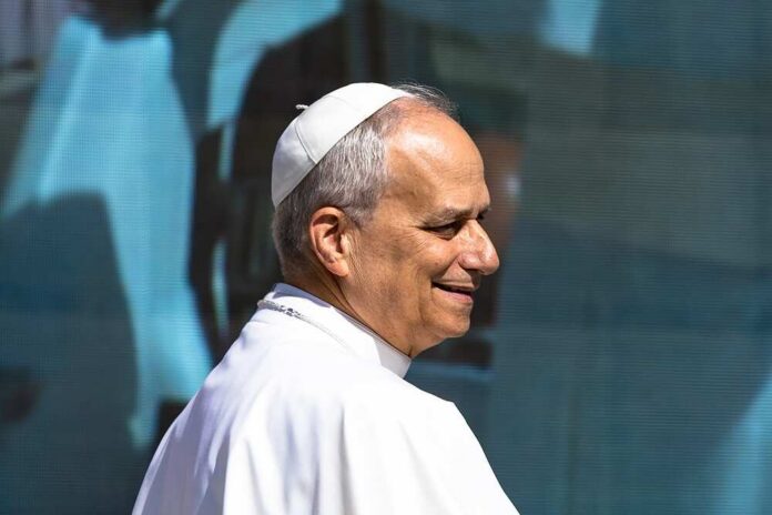 A religious leader in papal attire smiling during a public appearance