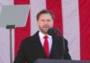 Man speaking at a podium with an American flag backdrop