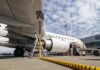 An airplane being fueled at an airport with visible ground support equipment