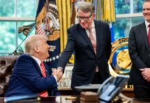 Two men shaking hands in an office setting