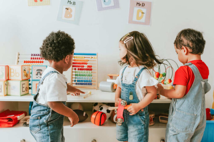 Three children engaged in play with educational toys in a colorful classroom