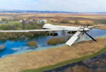 A military drone flying over a rural landscape with a river