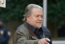 Man in casual attire gesturing while speaking outdoors