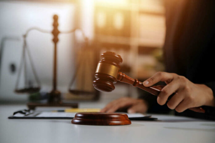 shutterstock2478909667jpg A gavel being struck on a desk in a courtroom setting