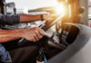 Deadly Crash Ignites Trucking Immigration Battle Close-up of a truck driver's hands on the steering wheel inside a vehicle