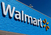 Walmart CRASHES Trillion-Dollar Ceiling! Walmart store sign against a bright blue wall