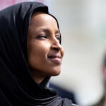 Explosive Omar Allegations — Ethics Breached? Woman wearing a black hijab looking thoughtfully into the distance