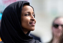 Explosive Omar Allegations — Ethics Breached? Woman wearing a black hijab looking thoughtfully into the distance