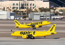 Two Spirit Airlines planes on a runway at an airport