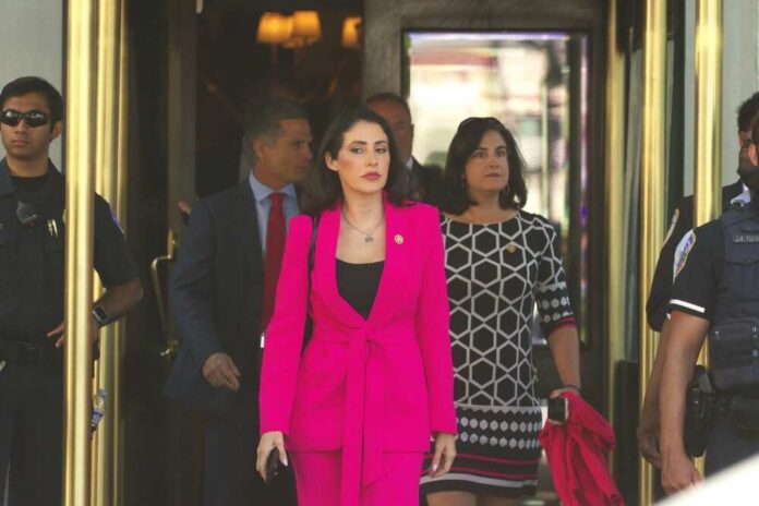 Woman in a bright pink suit walking out of a building