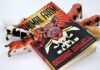 A copy of Animal Farm by George Orwell surrounded by toy animals