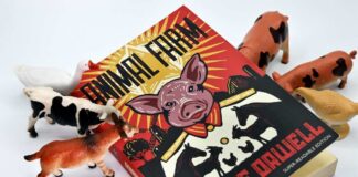 A copy of Animal Farm by George Orwell surrounded by toy animals