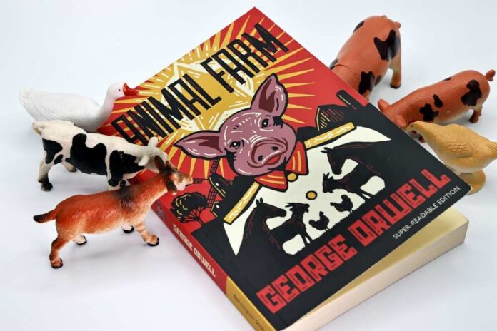 A copy of Animal Farm by George Orwell surrounded by toy animals