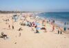 Bondi Beach Horror: ISIS Applauds, Sparks Outrage Crowded beach with people sunbathing and playing in the water