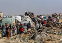 Gaza Chaos Erupts — Cameras Stayed Off? Displaced families with belongings crowd a rubble-strewn road